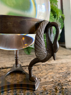 A large fortune teller's crystal ball on a bronze stand