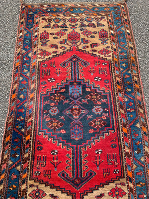 A long hand woven Persian red and blue ground rectangular rug