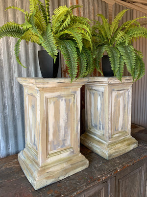 A pair of white pedestal stands
