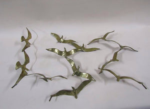 A trio of gilded bronze flocks of birds in flight