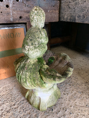 A cast stone birdbath with the figure of a fawn