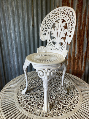 A white cast metal garden set - a large table and two chairs