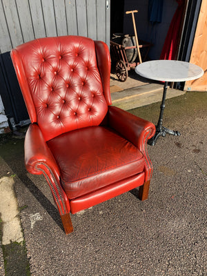 A red wingback Chesterfield recliner armchair