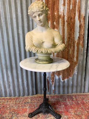 A black cast iron bistro table with marble top