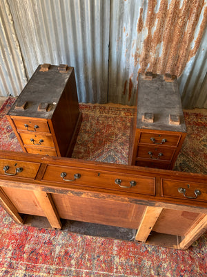 A mahogany pedestal desk with green leather top