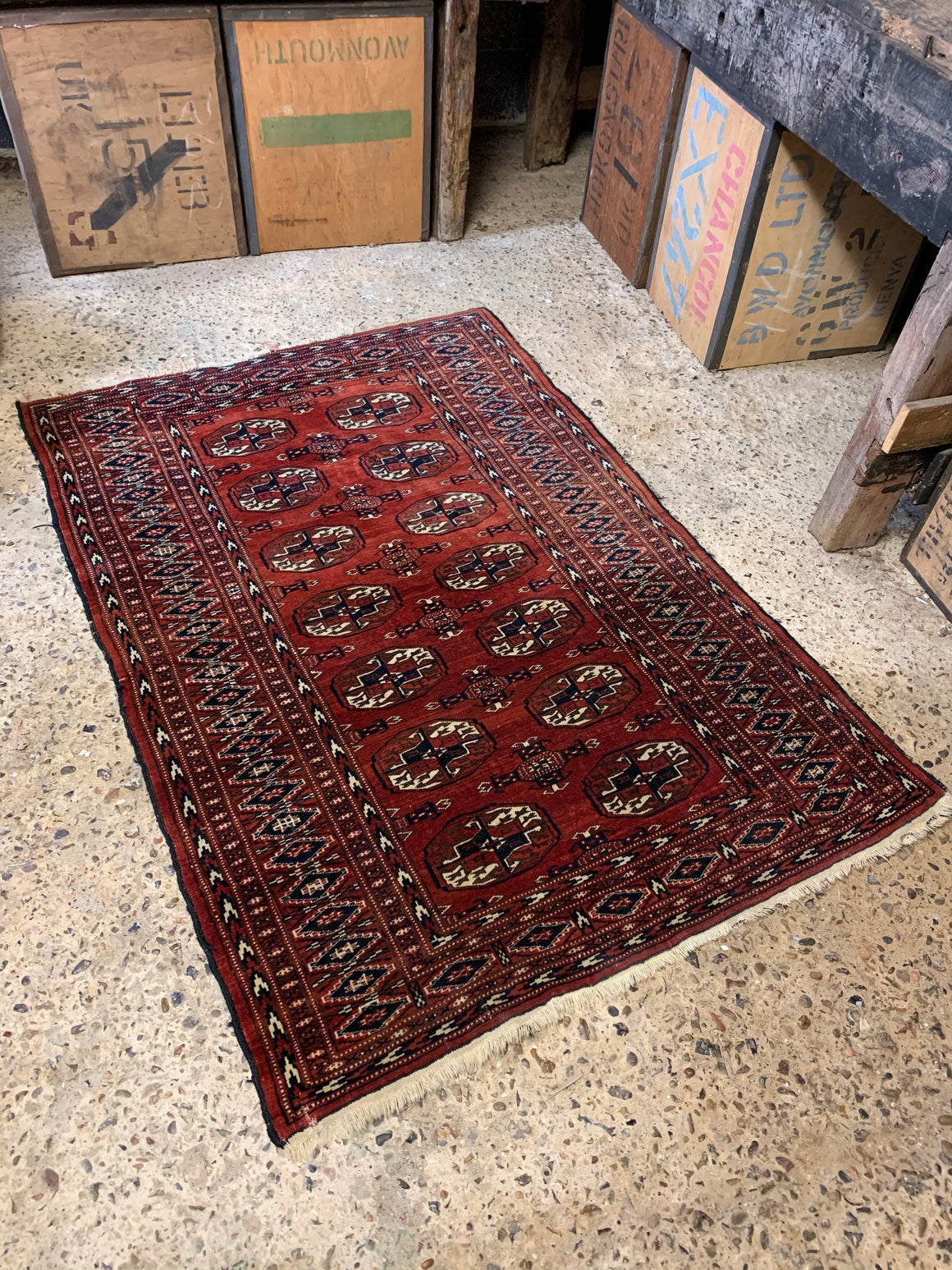 A hand woven Persian red ground rectangular rug with multiple lozenges