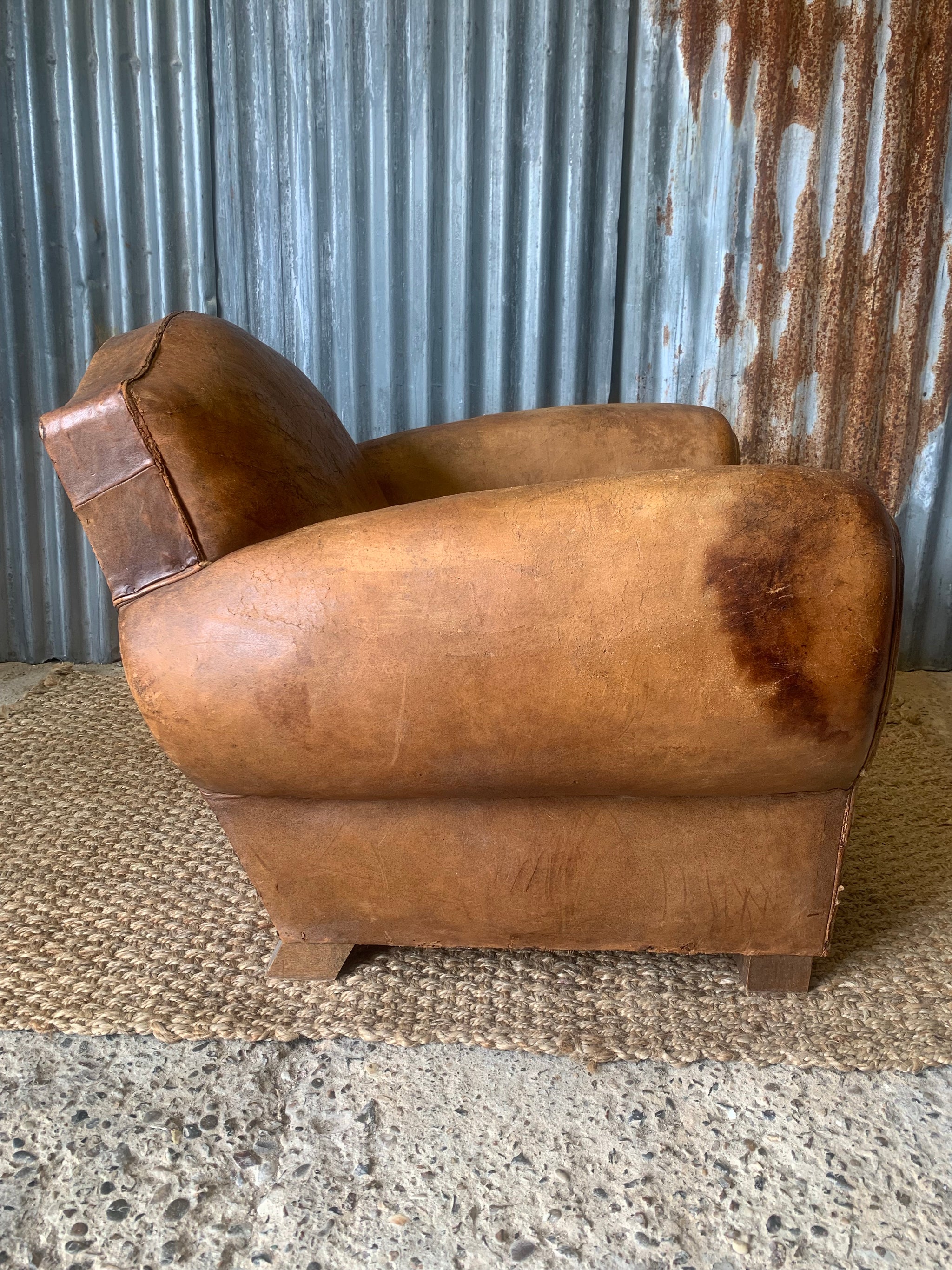 A tan leather club chair with moustache back Belle and Beast