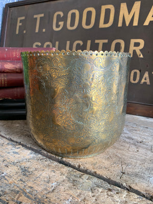 An ornately carved brass planter