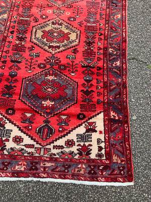 A hand woven Persian red ground rectangular rug