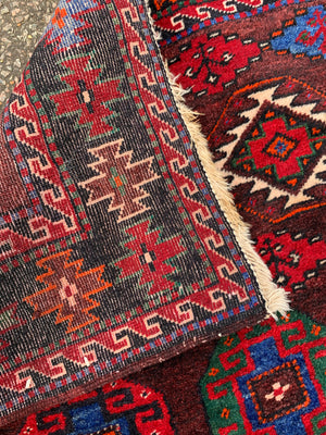 A large Persian red ground runner rug