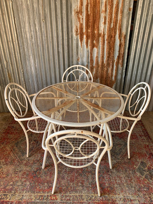 A white metal table and four chairs garden set