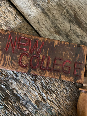 A wooden "New College" football rattle