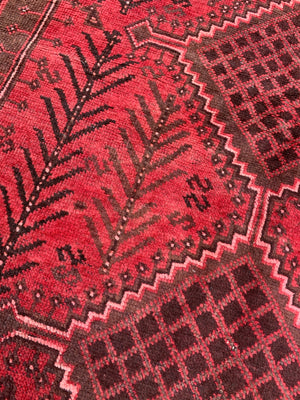 A large hand knotted Persian red ground rectangular rug