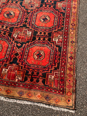 A large red ground Bokhara Persian rug with 'elephant foot' design