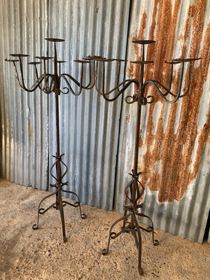 A Victorian pair of black cast iron floor standing church candelabra