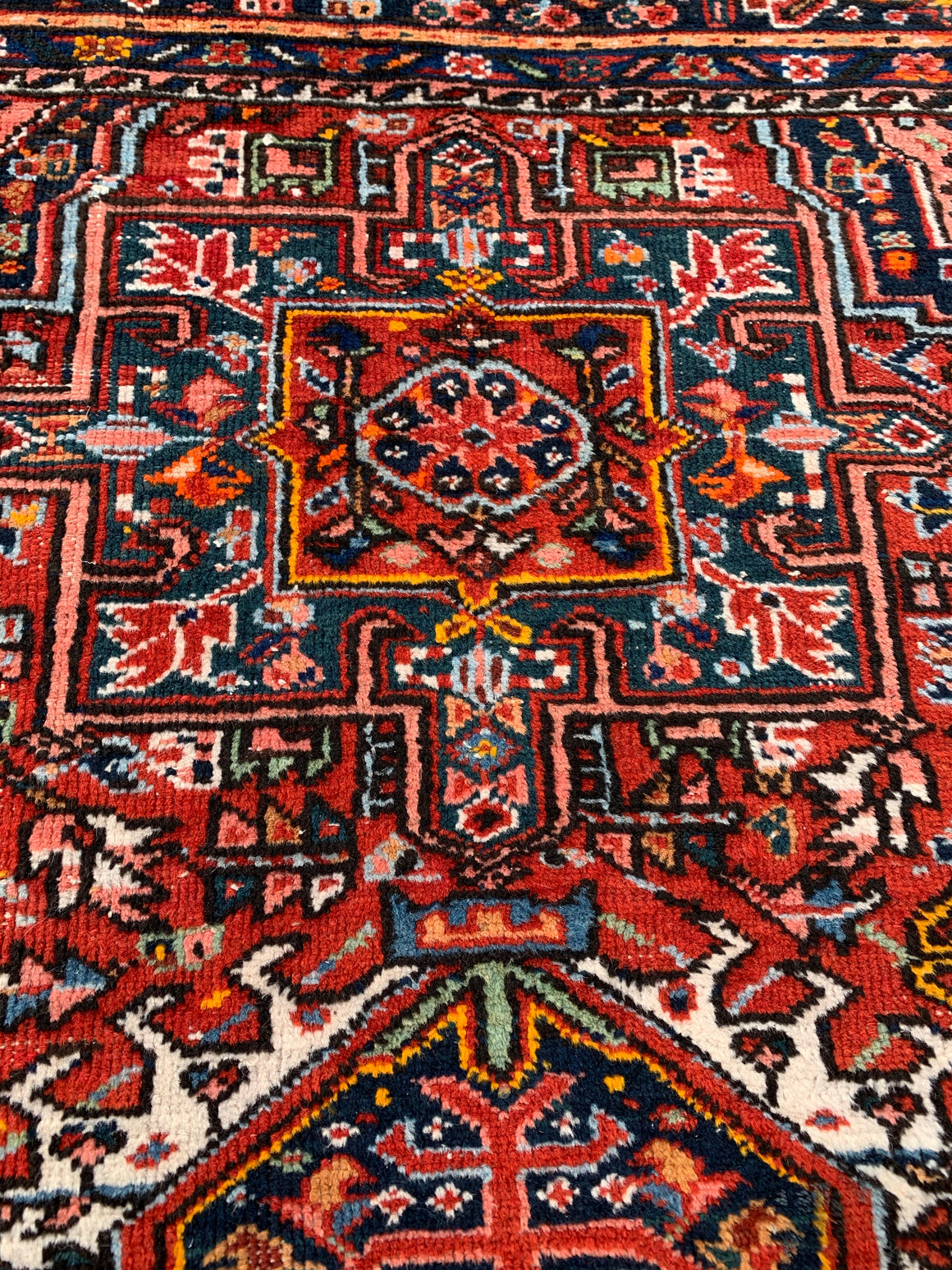 A large rectangular red ground Persian rug