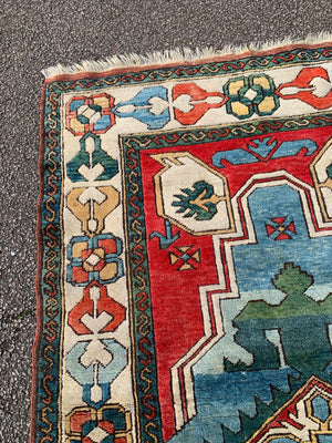 A hand woven Persian red, blue & green ground rectangular rug