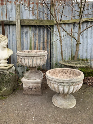 A pair of large cast stone urns