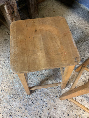 A pair of vintage wooden school laboratory stools