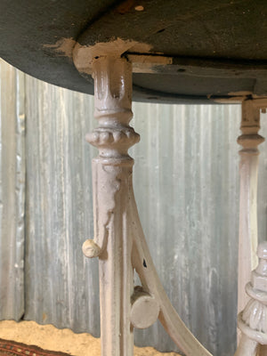 A white cast iron bistro garden table with wooden top