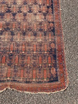 A hand woven Persian red ground small rectangular rug