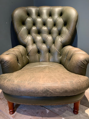 A small green leather Chesterfield armchair