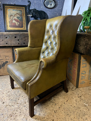 An apple-green wingback Chesterfield chair