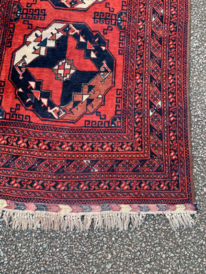 A red ground rug - 162cm x 102cm