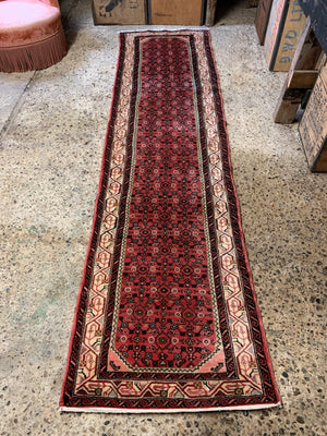 A long pink and red ground Persian Hosseinabad runner rug