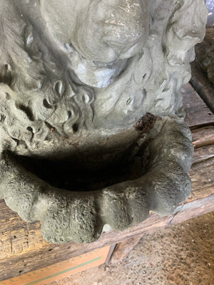 A pair of cast stone lion head wall planters