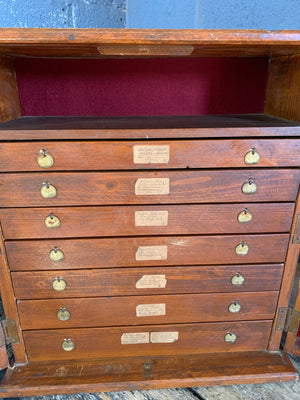 A bank of wooden table top watchmaker's drawers