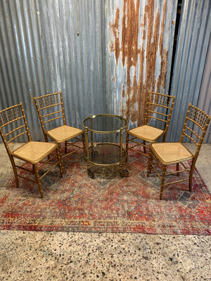 A set of four faux bamboo chairs with cane seats