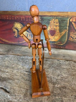 A mounted wooden artist's lay figure