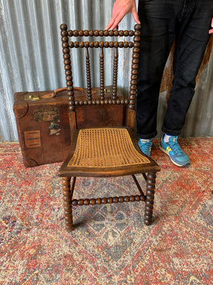 A 19th Century bobbin chair with cane seat by Bowen & Mallon