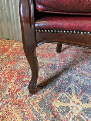 A red leather button back armchair