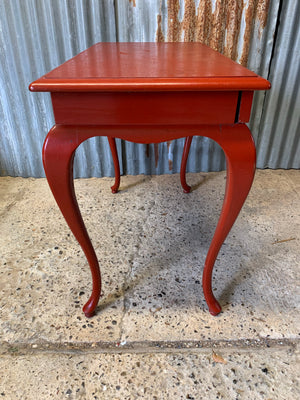 A red cabriole leg table