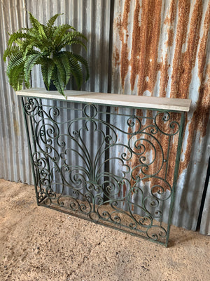 A tall cast iron strapwork console table with marble top