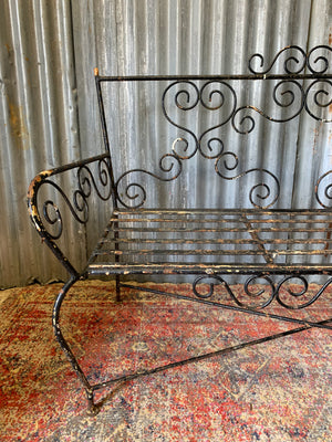 A wrought iron strapwork garden bench