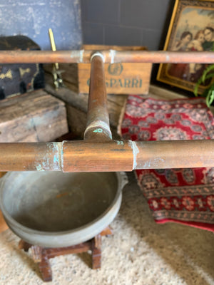 A vintage industrial copper pipe double clothing rack
