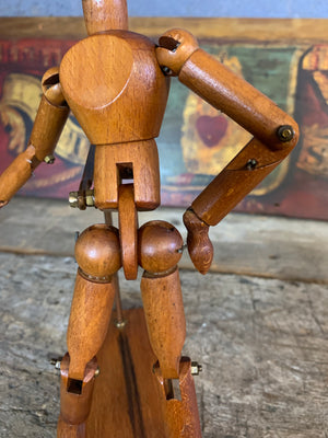 A mounted wooden artist's lay figure