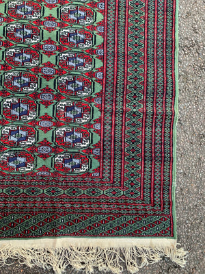 A Persian Bokhara rectangular rug - red/green tones