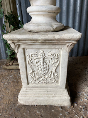 A cast stone bust of Venus (or Aphrodite) on a pedestal