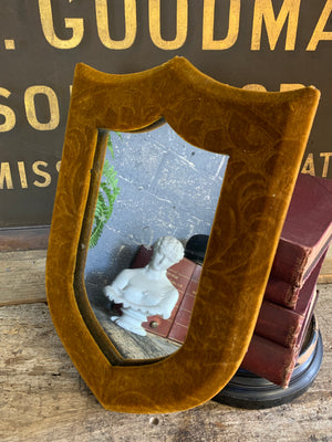 A Victorian gold velvet shield mirror