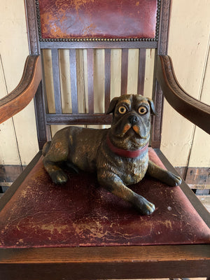 A recumbent pug dog figure with glass eyes