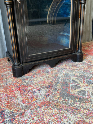 An ebonised display cabinet with glass door