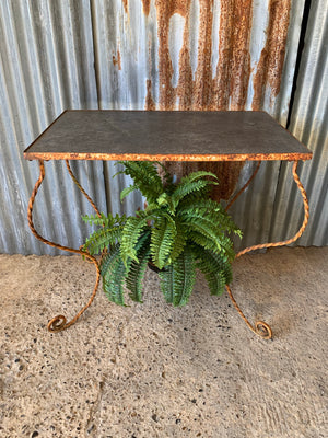 A twisted wrought iron garden table