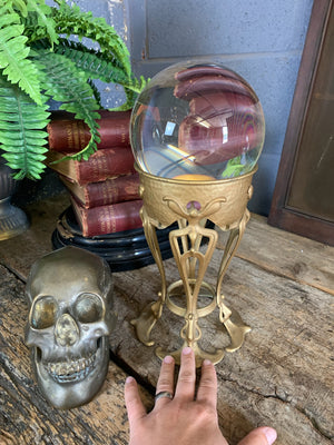 A fortune teller's crystal ball on a gold Art Nouveau stand