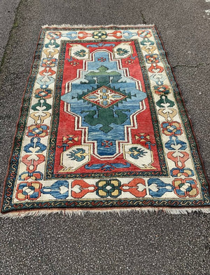 A hand woven Persian red, blue & green ground rectangular rug