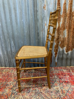 A set of four faux bamboo chairs with cane seats