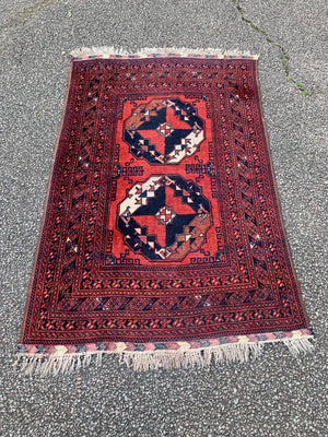 A red ground rug - 162cm x 102cm